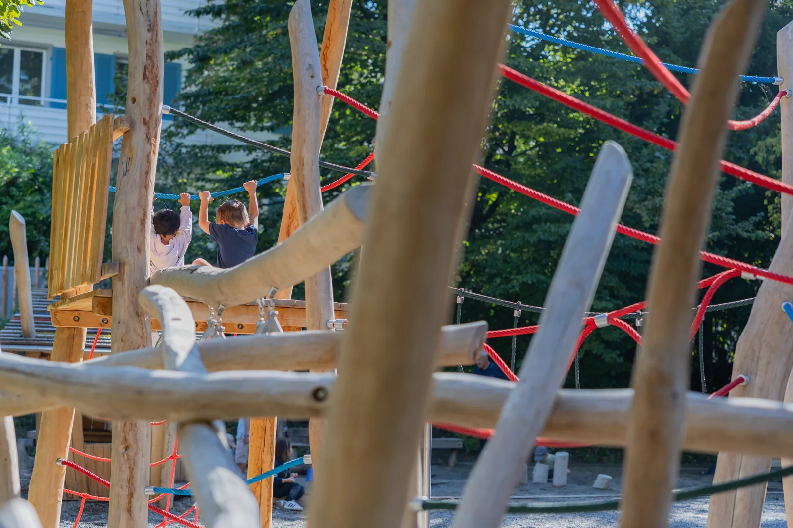 Zwei Kinder von hinten greifen nach einem Seil
